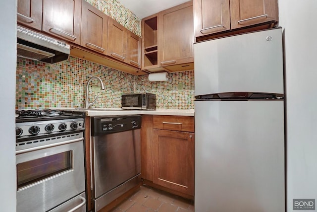 kitchen featuring light tile patterned floors, stainless steel appliances, backsplash, range hood, and sink