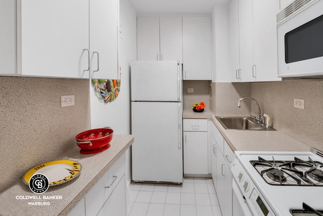 kitchen with sink, light tile patterned floors, white cabinets, white appliances, and backsplash