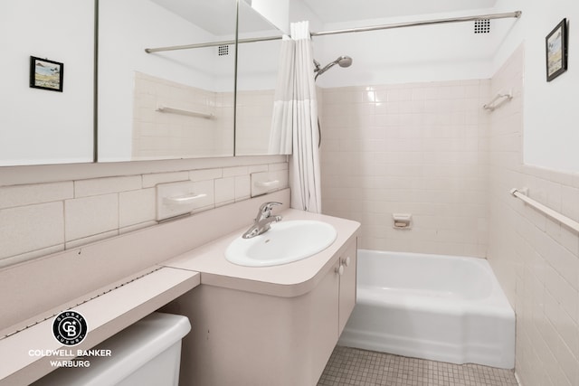 full bathroom featuring tile walls, tile patterned flooring, vanity, shower / tub combo, and toilet