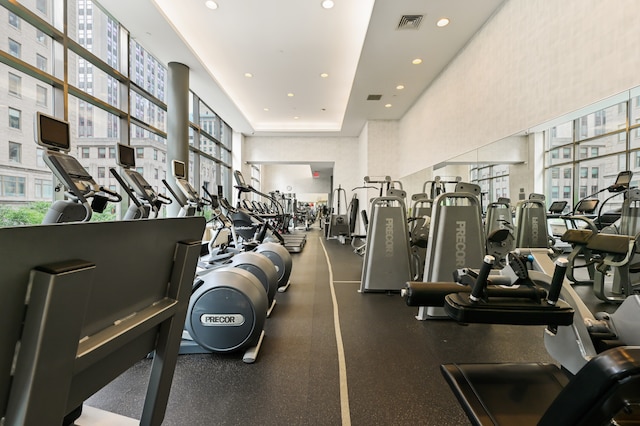 gym with recessed lighting, visible vents, and a towering ceiling