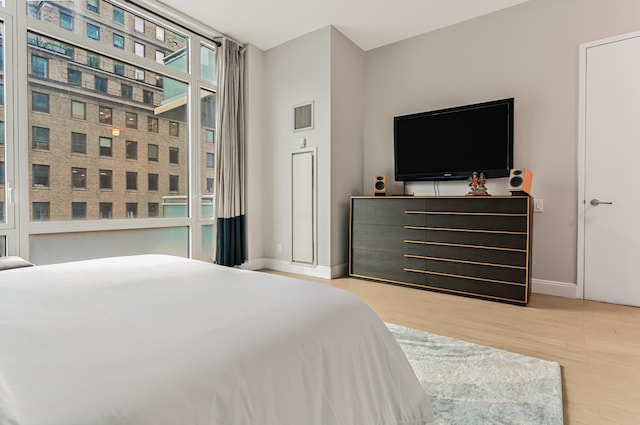 bedroom featuring visible vents, baseboards, and wood finished floors