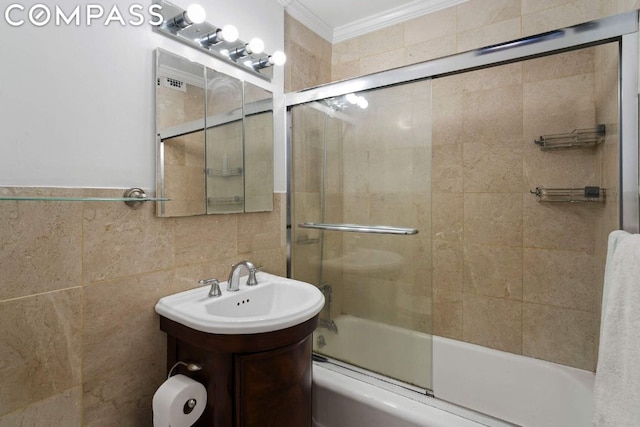 bathroom with tile walls, combined bath / shower with glass door, vanity, and ornamental molding