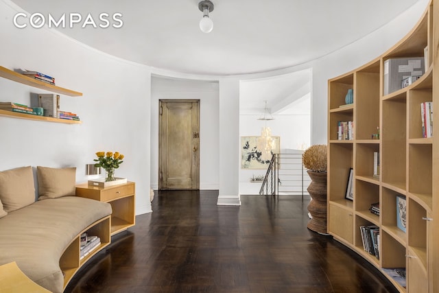 sitting room featuring wood finished floors, an upstairs landing, and baseboards