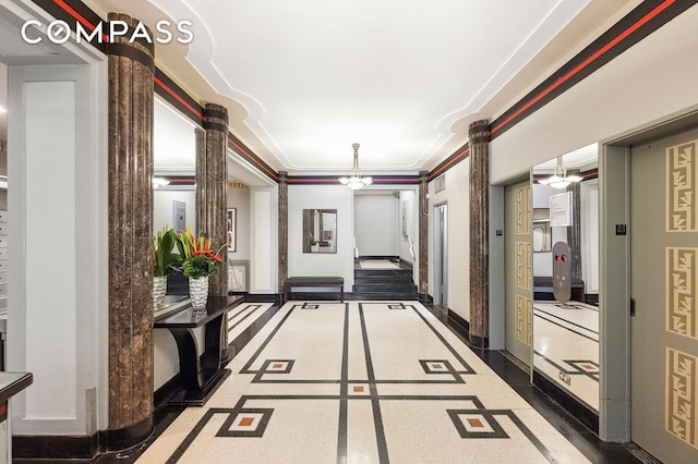 corridor featuring decorative columns, baseboards, and crown molding