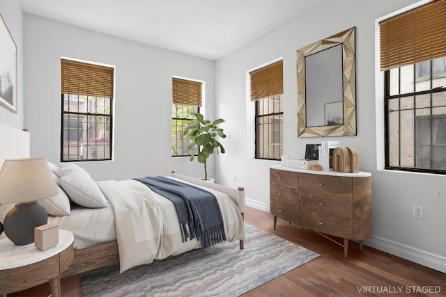 bedroom with dark hardwood / wood-style floors