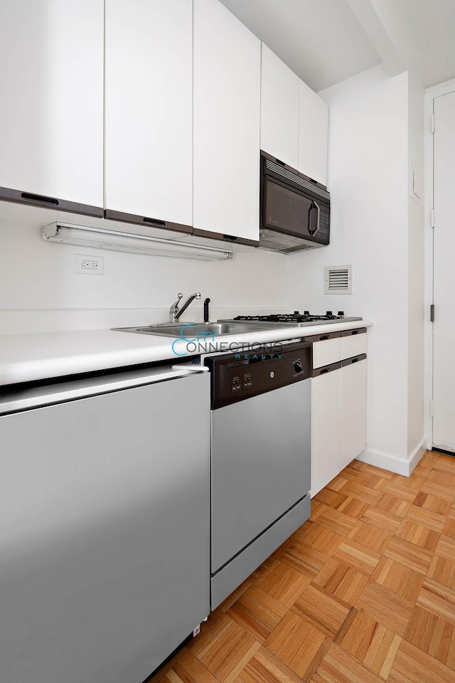 kitchen with visible vents, appliances with stainless steel finishes, white cabinetry, and light countertops