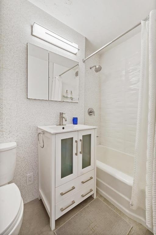 full bathroom featuring tile patterned flooring, vanity, shower / bath combination with curtain, and toilet