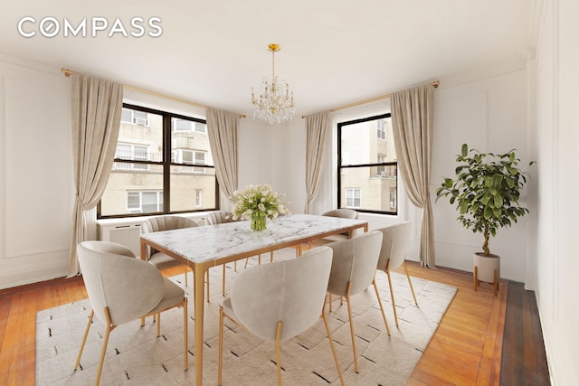 dining area featuring a notable chandelier, light wood-style flooring, and plenty of natural light