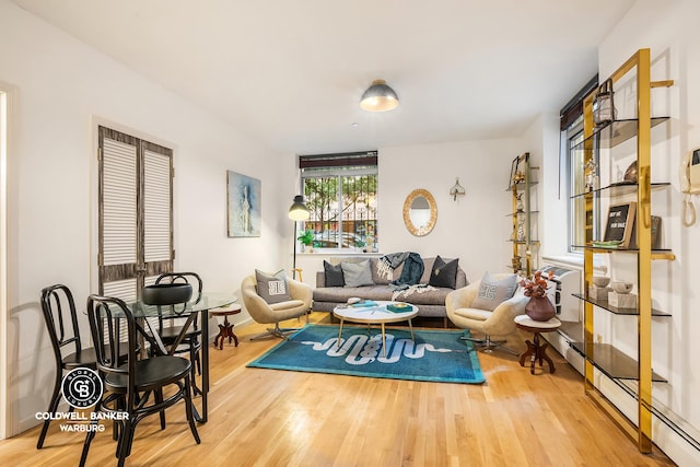 living room with baseboard heating and wood finished floors