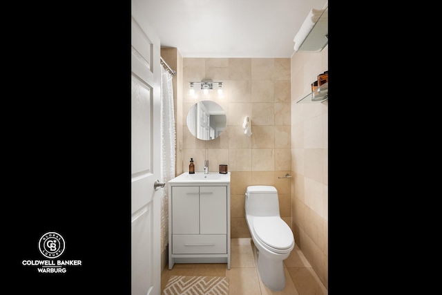 full bath with tile patterned flooring, toilet, tile walls, and vanity