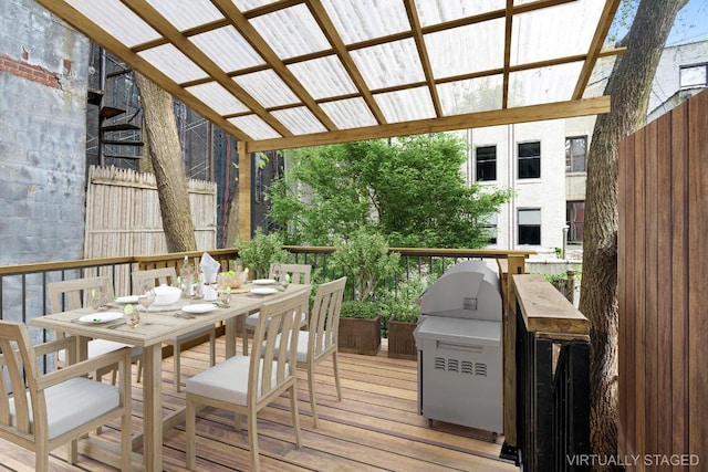 wooden deck featuring exterior kitchen, a pergola, and a grill