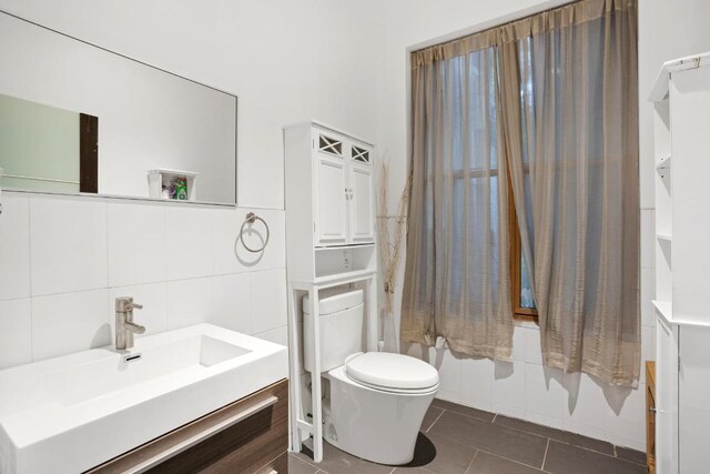 full bathroom with tile patterned flooring, toilet, tile walls, shower / bath combo, and vanity