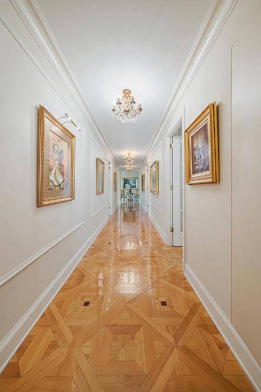 hallway with baseboards and ornamental molding