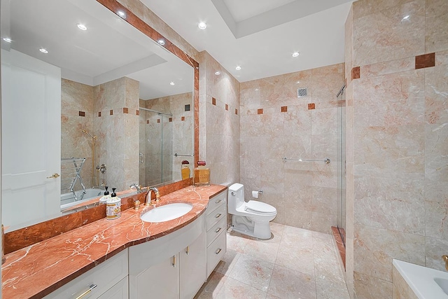 bathroom featuring tile walls, a stall shower, recessed lighting, toilet, and vanity