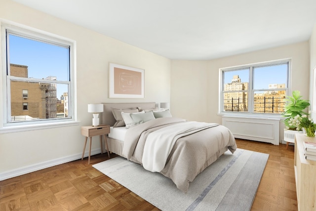 bedroom featuring parquet floors and multiple windows