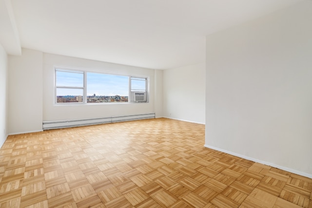 unfurnished room with cooling unit, light parquet floors, and baseboard heating