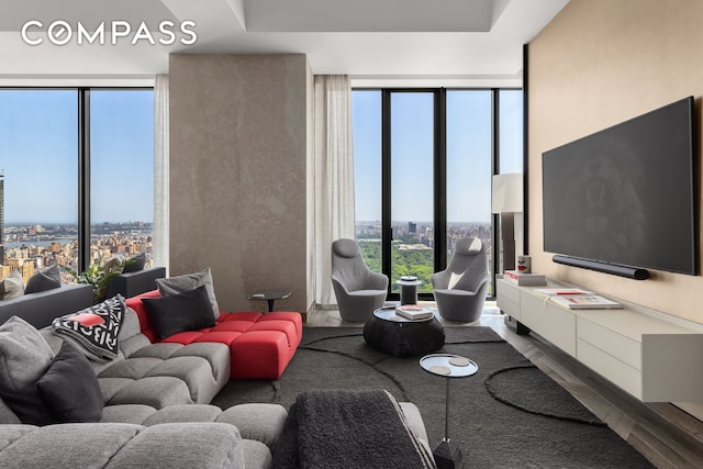 living area with floor to ceiling windows and wood finished floors