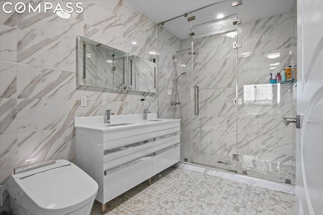 bathroom with a shower with door, vanity, and tile walls