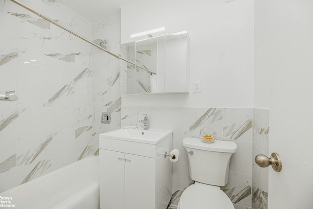 bathroom featuring vanity, tile walls, and toilet