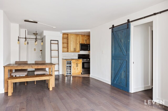 kitchen featuring stainless steel gas range oven, black microwave, a barn door, open shelves, and dark wood finished floors