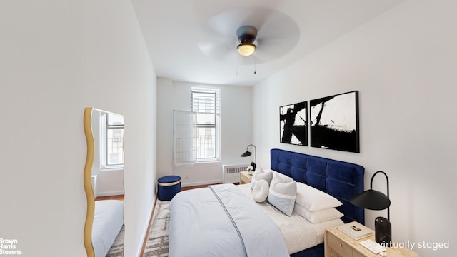 bedroom with ceiling fan and radiator heating unit