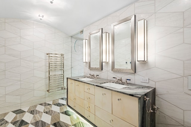 bathroom featuring tile walls, radiator, lofted ceiling, and vanity