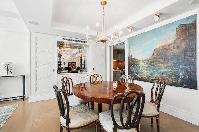 dining space featuring light parquet floors and a chandelier