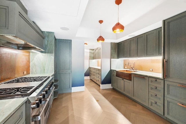 kitchen featuring light parquet flooring, sink, pendant lighting, and high end stainless steel range oven