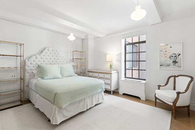 bedroom featuring hardwood / wood-style flooring, multiple windows, and beamed ceiling