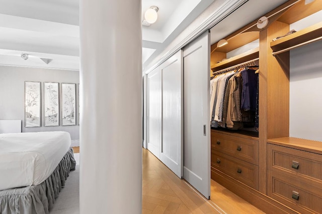 bedroom with light parquet flooring and a closet