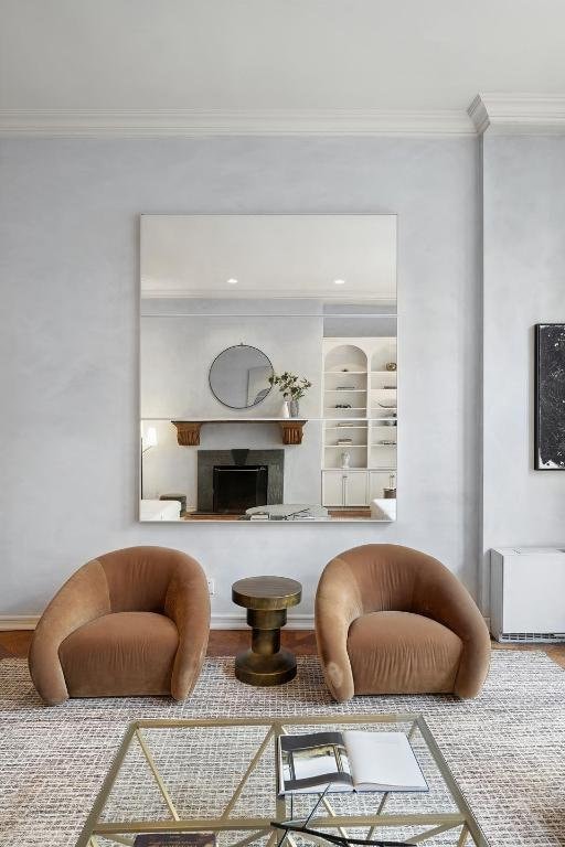 living room with built in shelves and ornamental molding