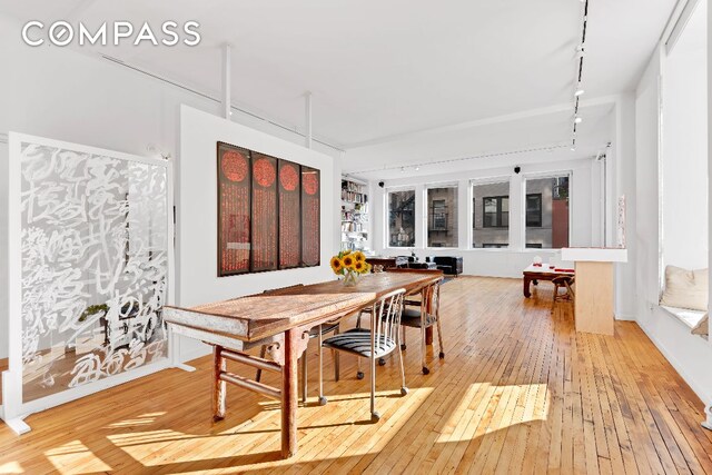 dining area featuring rail lighting and hardwood / wood-style floors