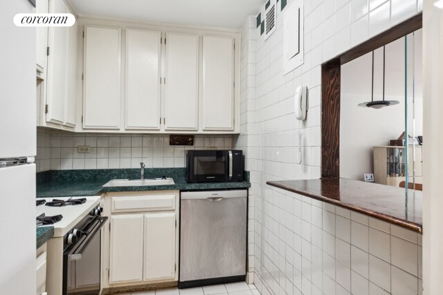 kitchen featuring white gas stove, dishwasher, white cabinetry, sink, and light tile patterned flooring