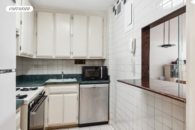 kitchen featuring dark countertops, white cabinetry, a sink, dishwasher, and white gas range oven