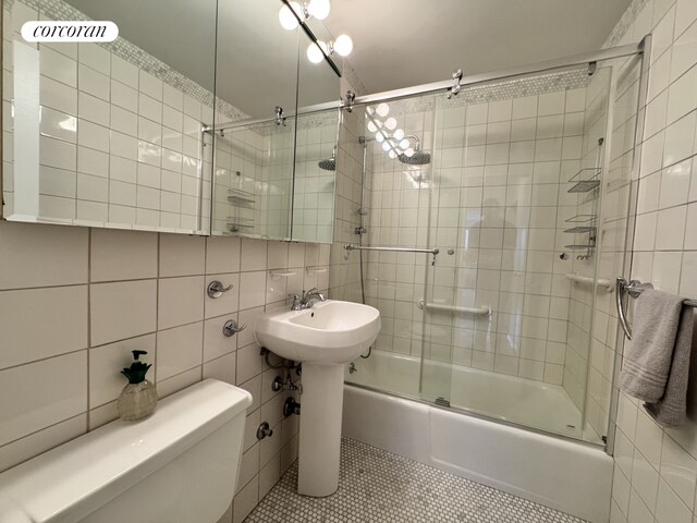 full bathroom featuring enclosed tub / shower combo, toilet, tile patterned flooring, and tile walls