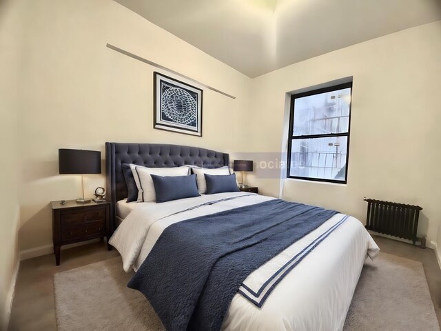 carpeted bedroom featuring radiator