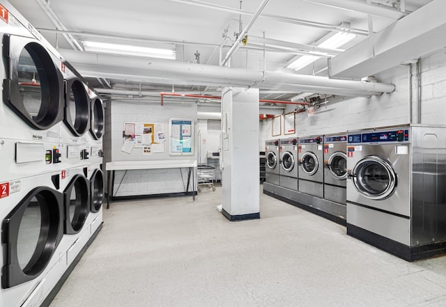 common laundry area with washing machine and clothes dryer, tile patterned floors, concrete block wall, and stacked washer and dryer