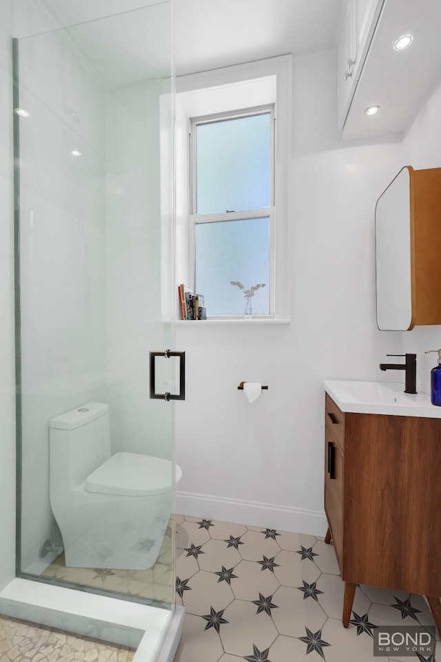 bathroom with toilet, vanity, baseboards, tile patterned floors, and a stall shower