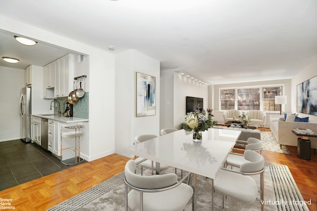 dining room featuring sink and dark parquet floors