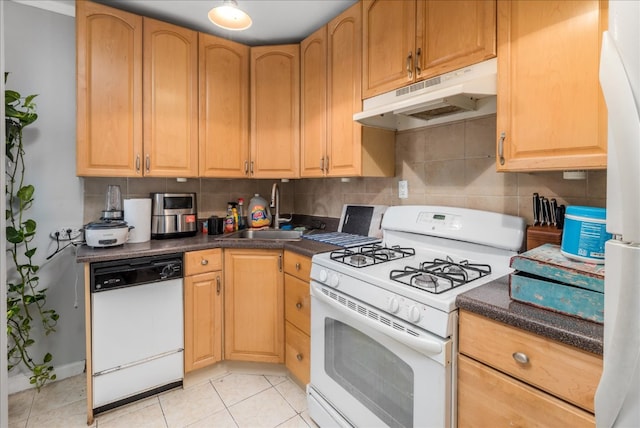 kitchen with tasteful backsplash, light tile patterned flooring, sink, and white appliances