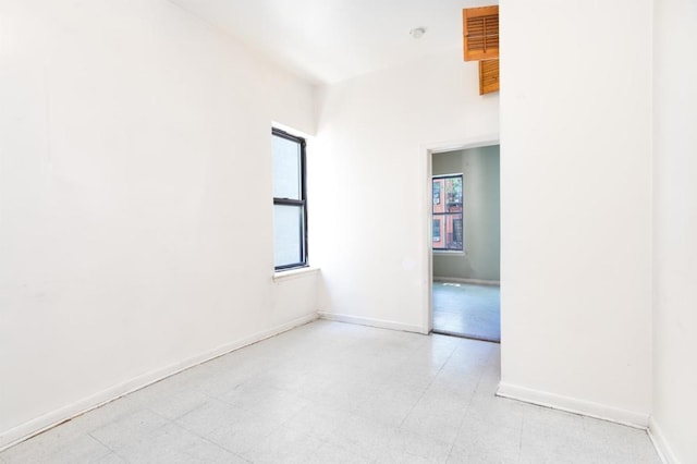 unfurnished room with light floors and baseboards