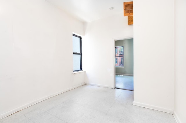 unfurnished room featuring light floors and baseboards