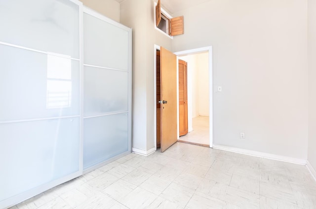 unfurnished bedroom with baseboards and tile patterned floors