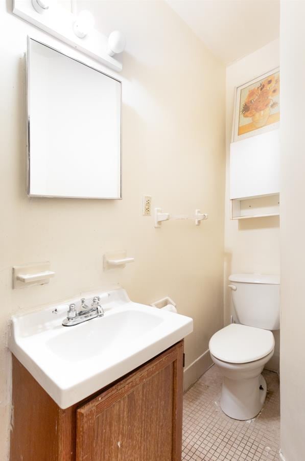 bathroom featuring tile patterned flooring, vanity, and toilet