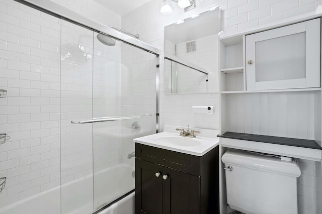 bathroom featuring visible vents, toilet, decorative backsplash, combined bath / shower with glass door, and vanity