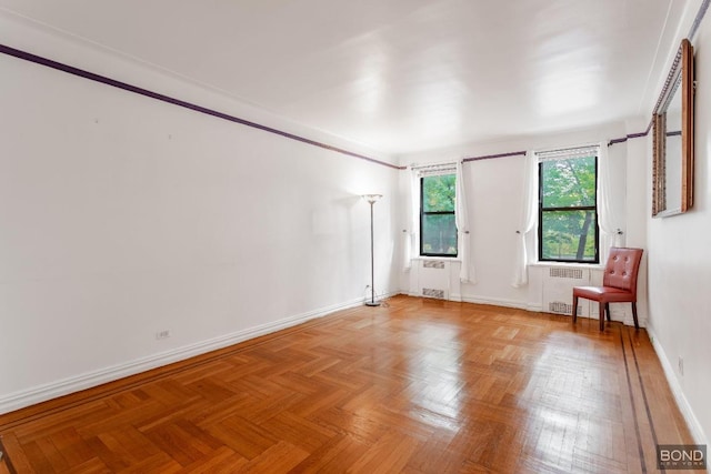 empty room featuring radiator heating unit, crown molding, and parquet flooring