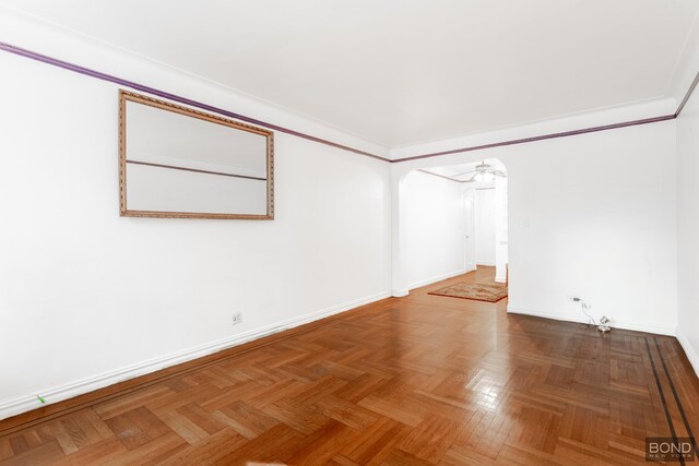 spare room featuring ornamental molding and parquet flooring