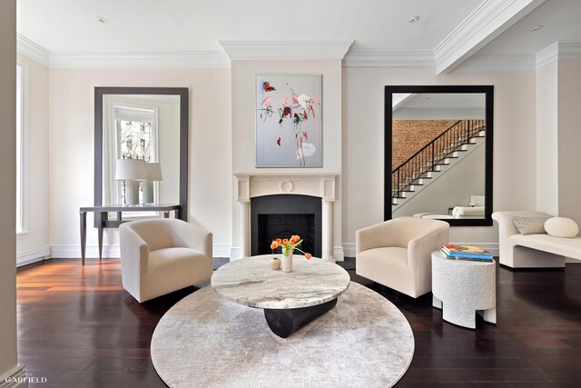 living room with dark wood finished floors, stairway, a lit fireplace, and ornamental molding