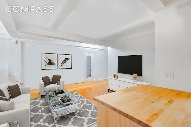 living room featuring beam ceiling and hardwood / wood-style floors