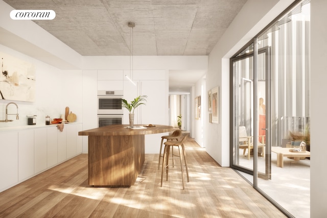 kitchen featuring butcher block counters, visible vents, light wood-style flooring, stainless steel double oven, and white cabinetry